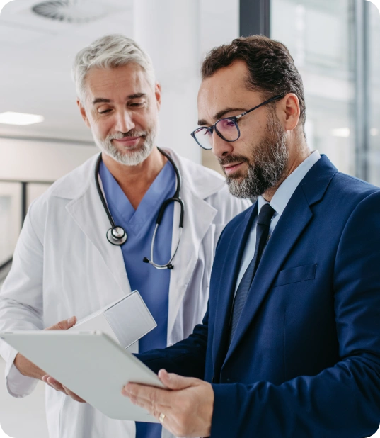 A doctor and executive review documents related to physician mapping.